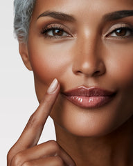 Femme souriante portant le gloss NEMESYS Ice Pearl, lèvres lissées et hydratées, effet anti-âge visible.