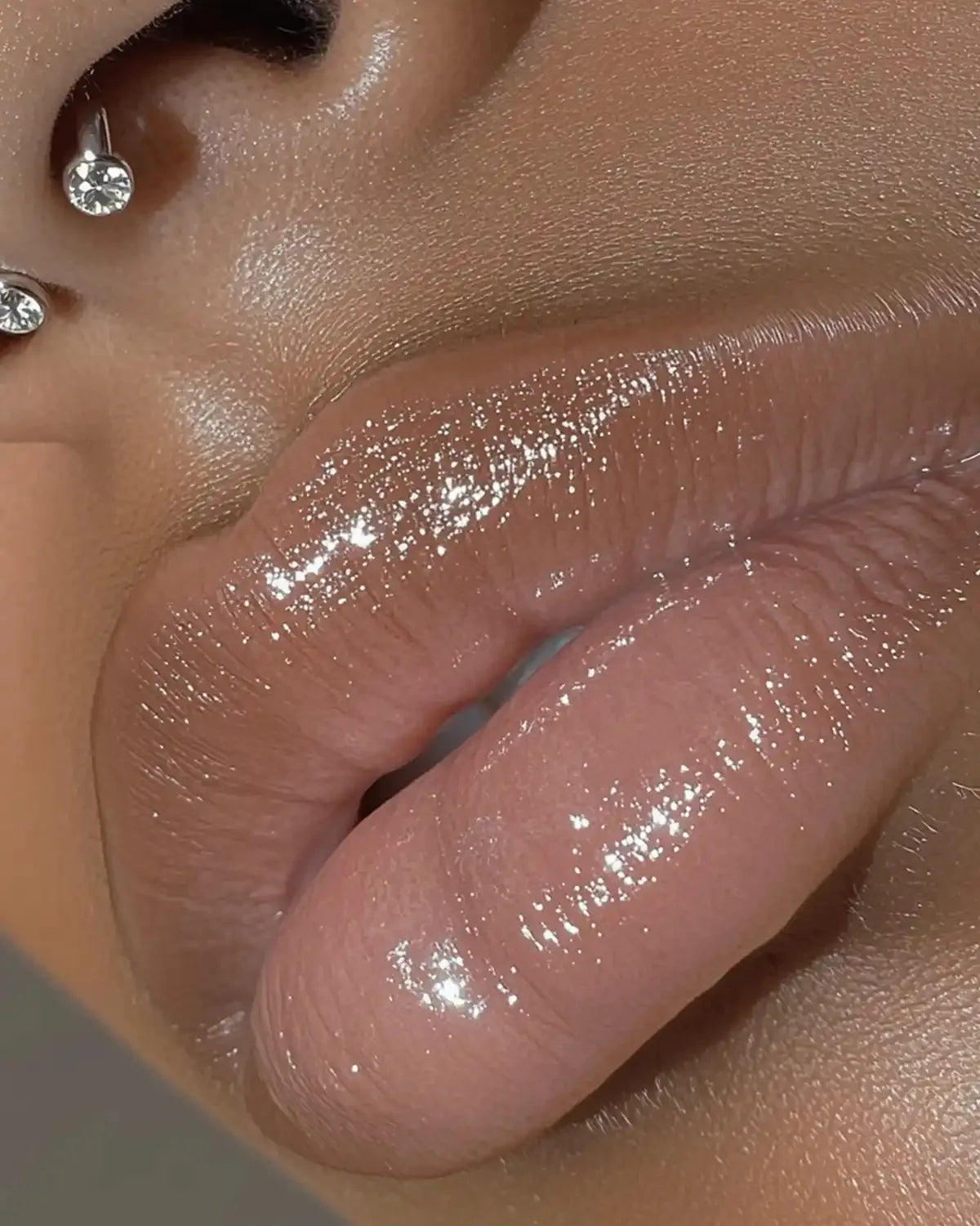 Close-up lèvres brillantes avec le gloss NEMESYS Ocean Bloom, effet miroir et volume hydraté.