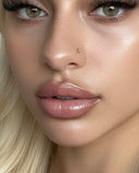 Femme blonde portant le gloss NEMESYS Volcano Kiss, lèvres repulpées effet injection.