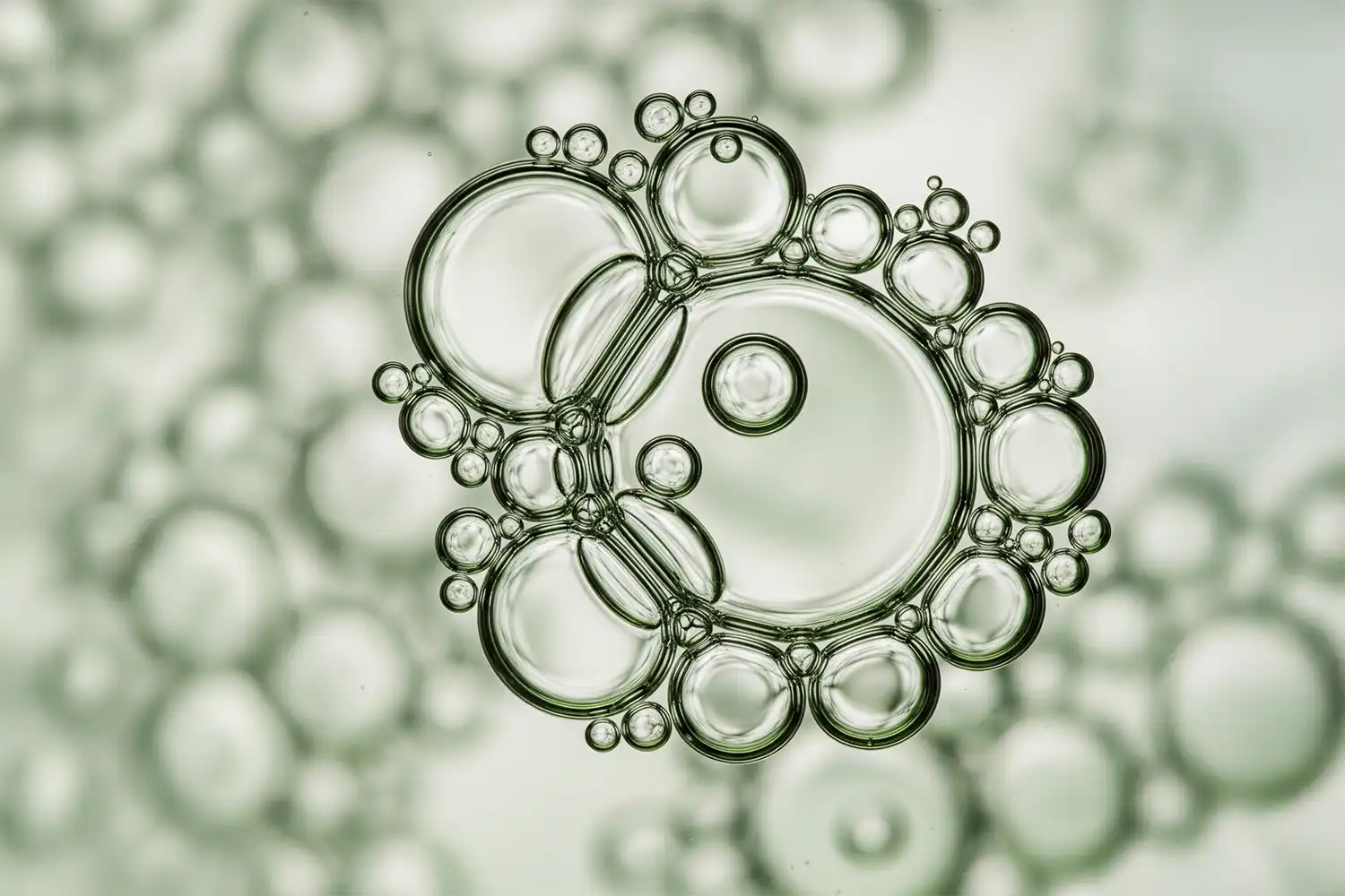 Liquide transparent vert et pur en macro, bulles légères illustrant la glycérine végétale, humectant hydratant naturel.