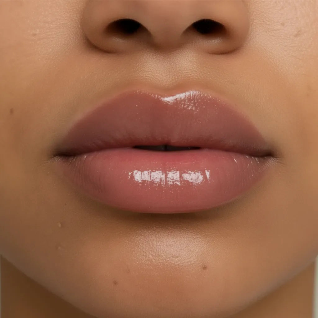 Gros plan de lèvres repulpées et brillantes après l’application du gloss Volcano Kiss de NEMESYS.