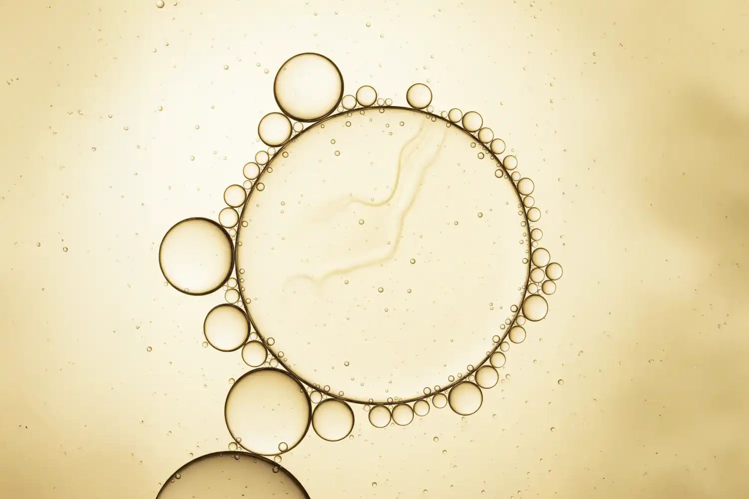 Texture fluide jaune en macro, évoquant la niacinamide, vitamine B3 universelle pour la peau.