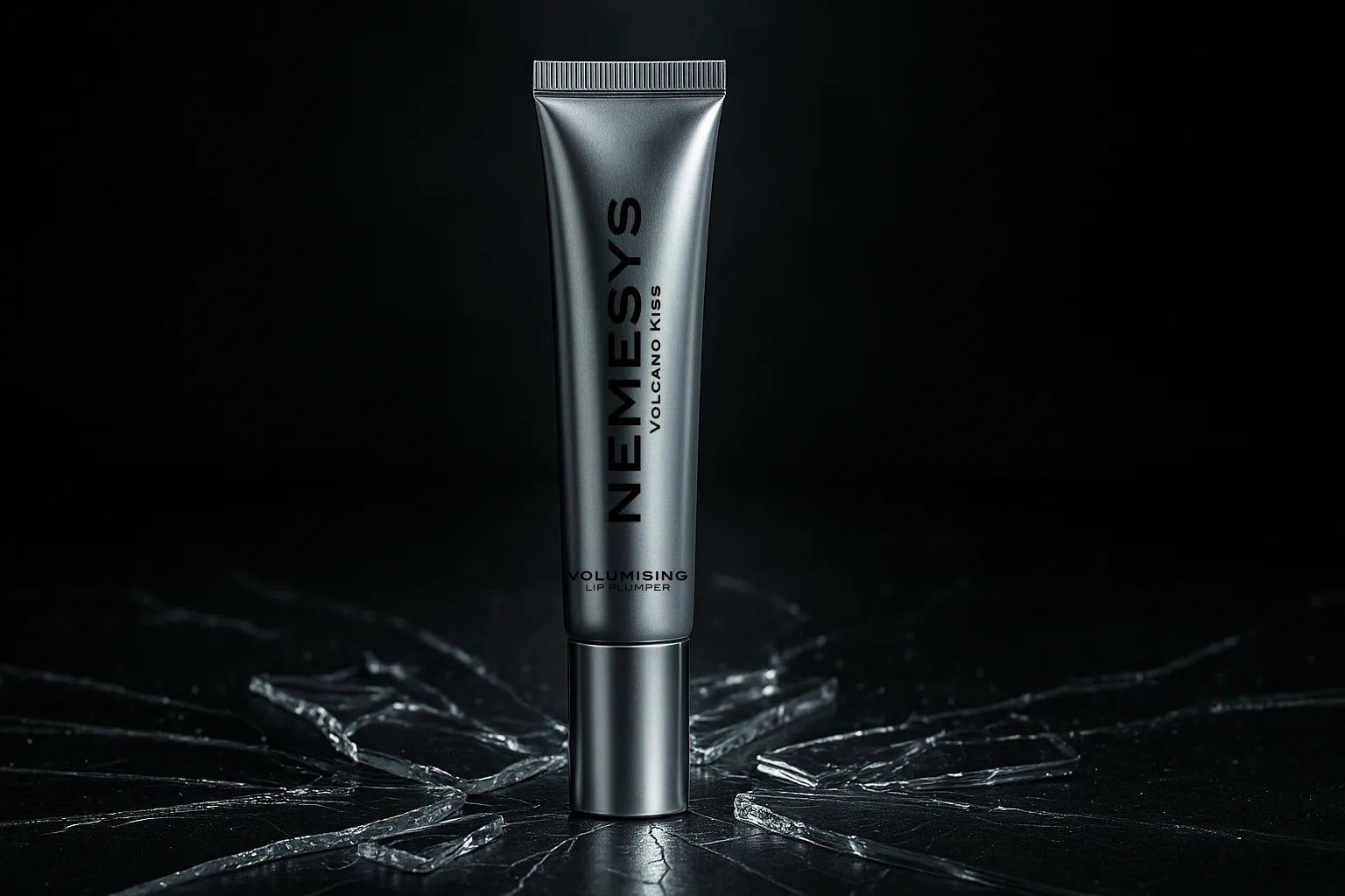 Tube de gloss repulpant NEMESYS Volcano Kiss posé sur une surface en verre fissurée, avec un éclairage dramatique mettant en valeur son design métallique et son effet volumateur.