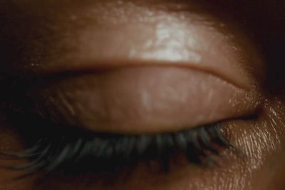 Gros plan sur un œil avec le reflet d’un gloss repulpant NEMESYS dans la pupille, symbolisant l’obsession du regard pour la beauté technologique.